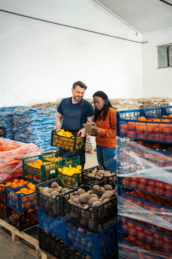 Food warehouse workers checking crates of fresh produce